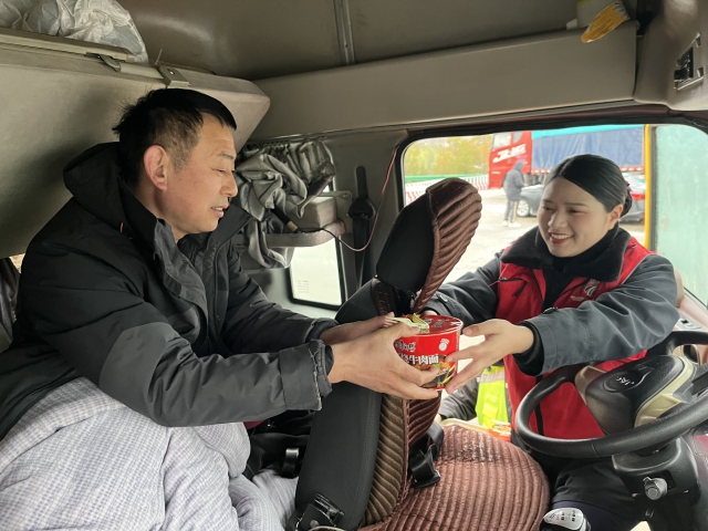 2月21日阜陽處毛集站李方月在道口為滯留司乘提供簡易餐食。.JPG